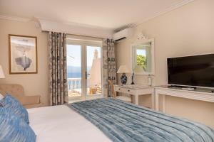 a bedroom with a bed and a desk and a television at Hôtel Les Mouettes - Teritoria in Ajaccio +83 photos