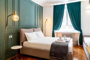 a bedroom with a bed with green walls and a window at Turin Central Suite in Turin