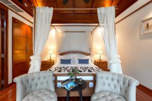 a bedroom with a bed with two chairs and a table at Katamanda B2 Tropical Pool Villa Kata Beach in Kata Beach +43 photos