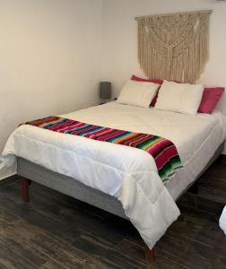 a large bed with a colorful blanket on it at Sol de México in Isla Mujeres
