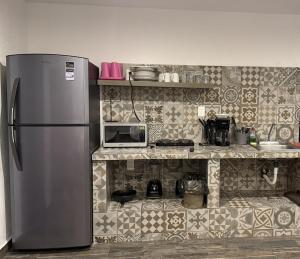 a kitchen with a stainless steel refrigerator and a counter at Sol de México in Isla Mujeres