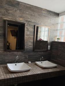 a bathroom with two sinks and two mirrors at Sol de México in Isla Mujeres +26 photos