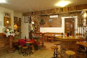 a restaurant with tables and chairs and a brick wall at Gostilna in prenočišča Gedžo in Novo Mesto