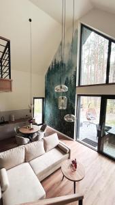 a living room with a couch and tables at Roztoczańska Stodoła in Majdan Sopocki