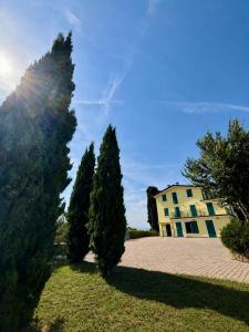 a group of trees in front of a building at La Porta del Lugana - Albergo Quattro Pini in Pozzolengo