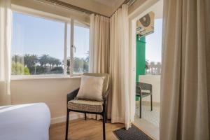 a room with a chair and a window with a view at Elegant Seaview Suite 1 in Swakopmund