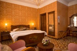 een slaapkamer met een groot bed en een spiegel bij Cankaya Konaklari Hotel in Hatay