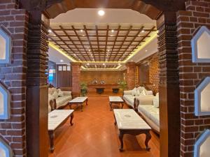a lobby with couches and tables and a brick wall at Shine Boutique Hotel in Kathmandu