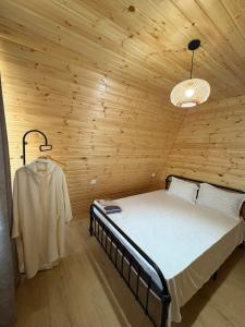 a bedroom with a bed in a wooden room at CottageNEO in Charnali