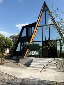 a black house with a bench in front of it at CottageNEO in Charnali