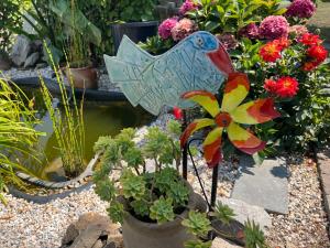 a garden with flowers and a bird in a pot at Le temps d une escapade vendéenne in Saint-Gervais +9 photos