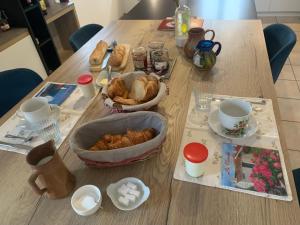 a table with a bunch of pastries and cups on it at Le temps d une escapade vendéenne in Saint-Gervais