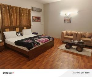 a bedroom with a bed and a couch and a chair at Hotel Royal Inn in Karachi +12 photos