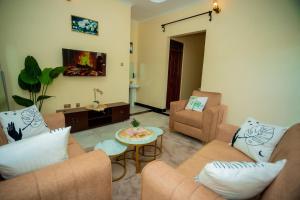 a living room with two couches and a table at Pristine Stays in Moshi