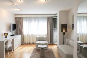 a white living room with a desk and a chair at VISIONAPARTMENTS Freyastrasse - self check-in in Zurich