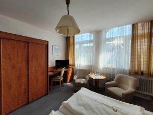 ein Hotelzimmer mit einem Bett, einem Schreibtisch und einem Tisch in der Unterkunft Hotel Rosengarten in Bad Salzuflen