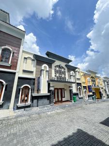 a row of buildings on a cobblestone street at Adiputra Guesthouse Tata Bumi by HomiQ in Yogyakarta