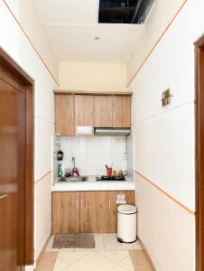 a small kitchen with wooden cabinets and a sink at Adiputra Guesthouse Tata Bumi by HomiQ in Yogyakarta