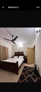 a bedroom with a large bed and a black rug at CH guest house in Murree