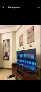 a living room with a large flat screen tv at CH guest house in Murree