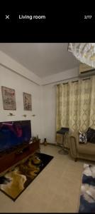 a living room with a television and a couch at CH guest house in Murree +4 photos
