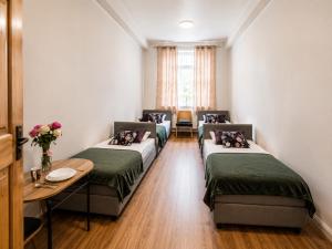 a room with four beds and a table with flowers at Hostel KASZUBSKA in Wrocław