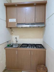 a kitchen with a stove and a sink at Adiputra Guesthouse Tata Bumi by HomiQ in Yogyakarta +13 photos