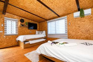 a bedroom with two beds and a flat screen tv at השקט של כליל - בקתה קסומה בטבע עם בריכה פרטית in Clil +11 photos