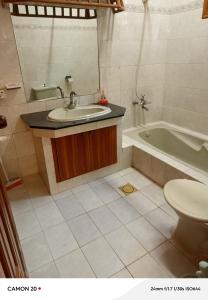 a bathroom with a sink and a tub and a toilet at Hotel Royal Inn in Karachi