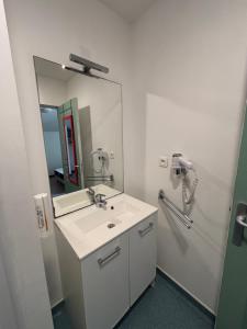 a bathroom with a sink and a mirror at Hôtel 2 Étoiles centre ville in Mont-de-Marsan