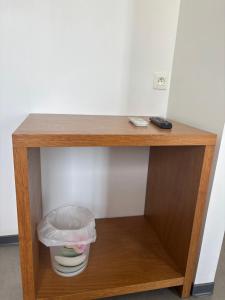 a small wooden shelf with a trash can on it at Hôtel 2 Étoiles centre ville in Mont-de-Marsan