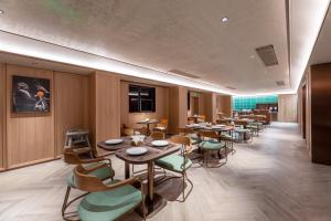 a restaurant with tables and chairs in a room at Orange Hotel Hangzhou Joy City in Hangzhou