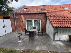 a patio with a table and chairs and a building at Loft Hesel, 35232 in Hesel