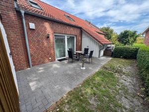 a patio with a table and chairs next to a brick building at Loft Hesel, 35232 in Hesel