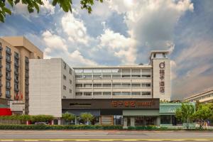 a large white building with a clock on it at Orange Hotel Hangzhou Joy City in Hangzhou