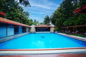 a large blue swimming pool next to a building at Jal Mahal Resort and Spa in Mysore