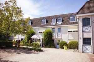 an apartment building with a courtyard in front of it at NordWest-Hotel Bad Zwischenahn in Bad Zwischenahn