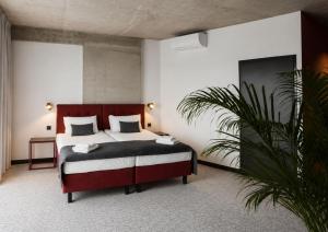 a bedroom with a bed and a potted plant at Arche Hotel Piła in Piła