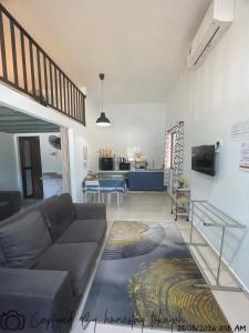 a living room with a couch and a kitchen at Homestay Studio TOKAYOH in Kota Bharu