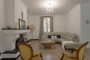 a living room with a couch and a fireplace at L'Ecrin des Corbières in Treilles