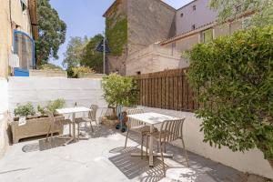 a patio with tables and chairs and a fence at L'Ecrin des Corbières in Treilles