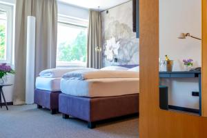 two beds in a hotel room with a window at Haus der Begegnung in Innsbruck