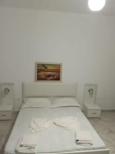 a white bed in a room with two night stands at Rooms New DiamonD in Durrës