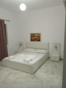 a white bedroom with a bed in a room at Rooms New DiamonD in Durrës