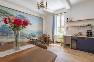 a kitchen and dining room with a vase of flowers on a table at L'Ecrin des Corbières in Treilles