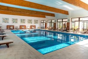 ein Pool in einem Hotel mit Stühlen und Tischen in der Unterkunft Lazoo Experience in Pitaru