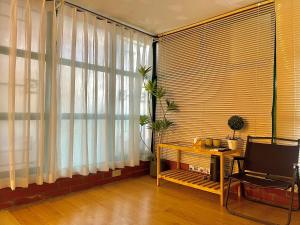a living room with a table and a large window at Old House Homestay in Hanoi