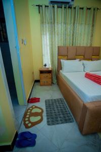 a bedroom with a bed and a rug on the floor at Pristine Stays in Moshi