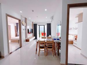 a dining room and living room with a table and chairs at Ina apartment - Nera garden Hue in Hue