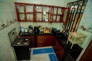 a small kitchen with wooden cabinets and a stove at Pristine Stays in Moshi